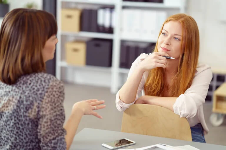 Two women having a conversation in an office